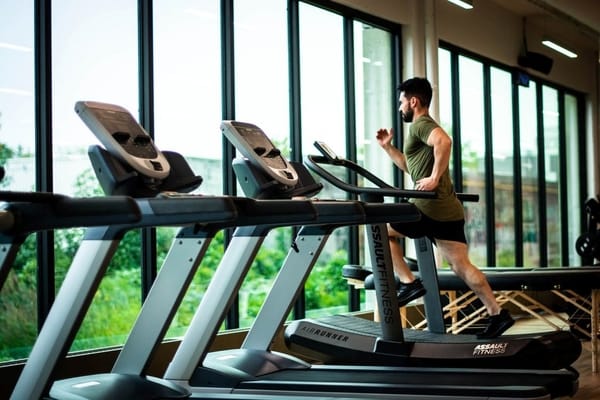 Man on thread mill in gym